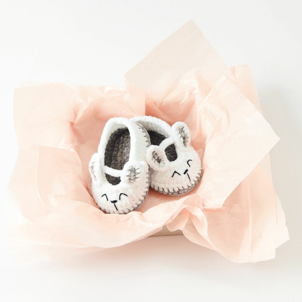 Kit crochet Ricorumi Lapin pour chaussons bébé sur une couverture douce, ambiance déco Nilli Nilli.