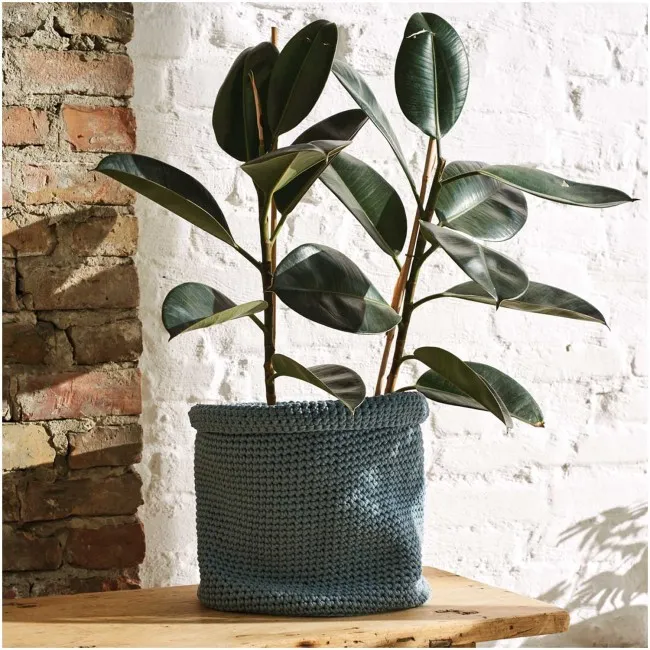 Un cache-pot bleu gris texturé réalisé avec du fil ruban au crochet
